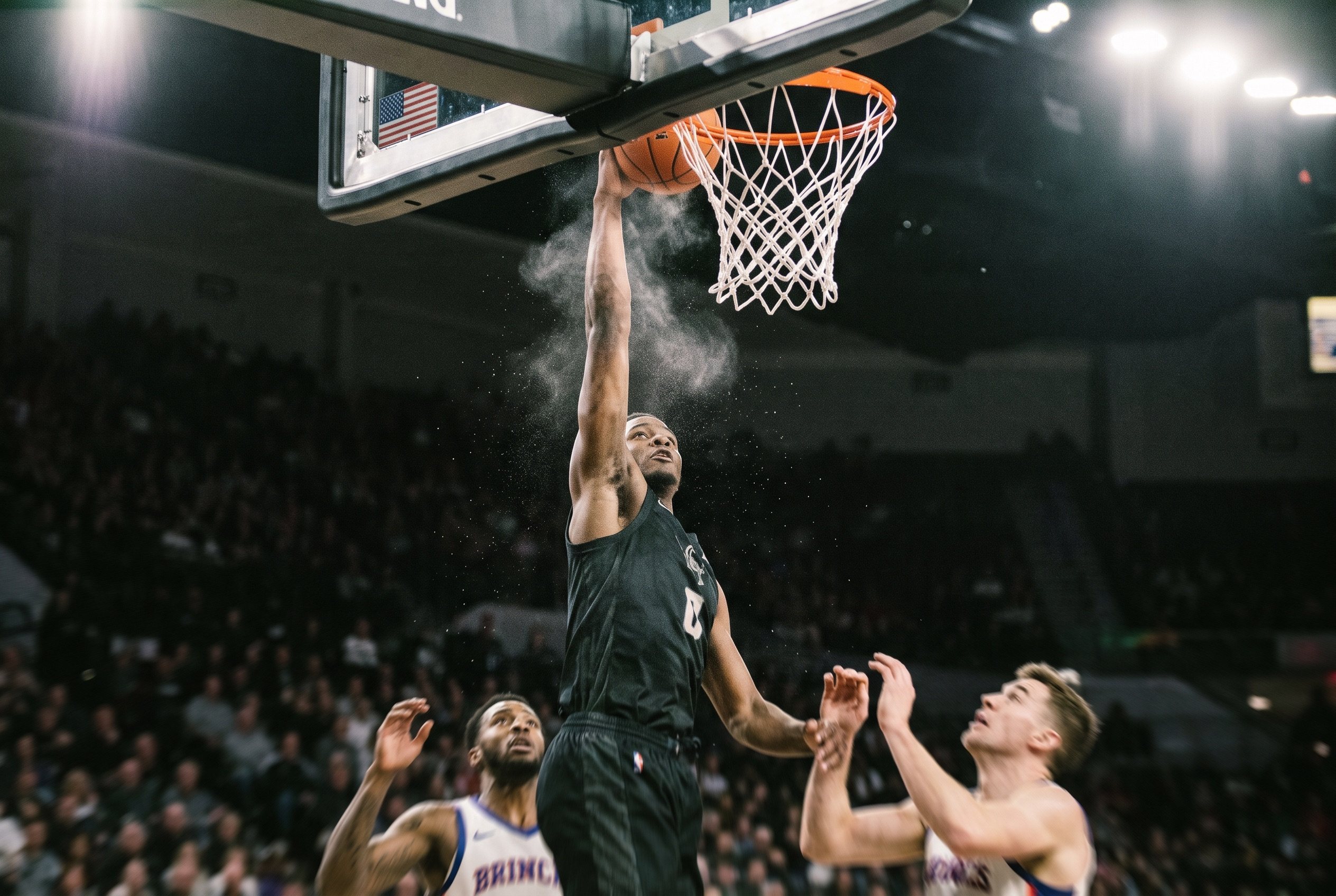 A basketball player at the top of a dunk, arms extended above the rim, arena lights behind him